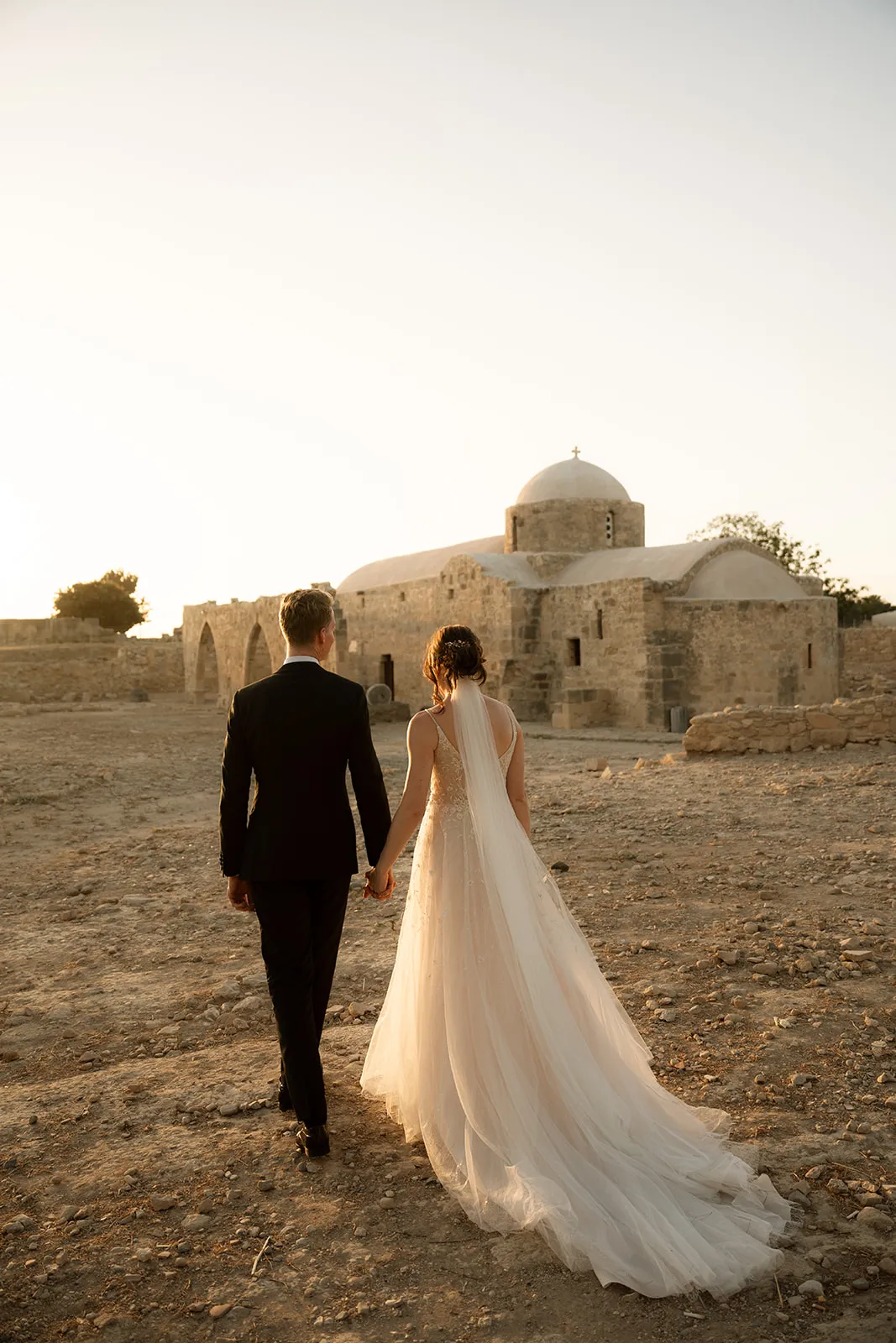 Couple walking to church at golden hour — Cyprus wedding